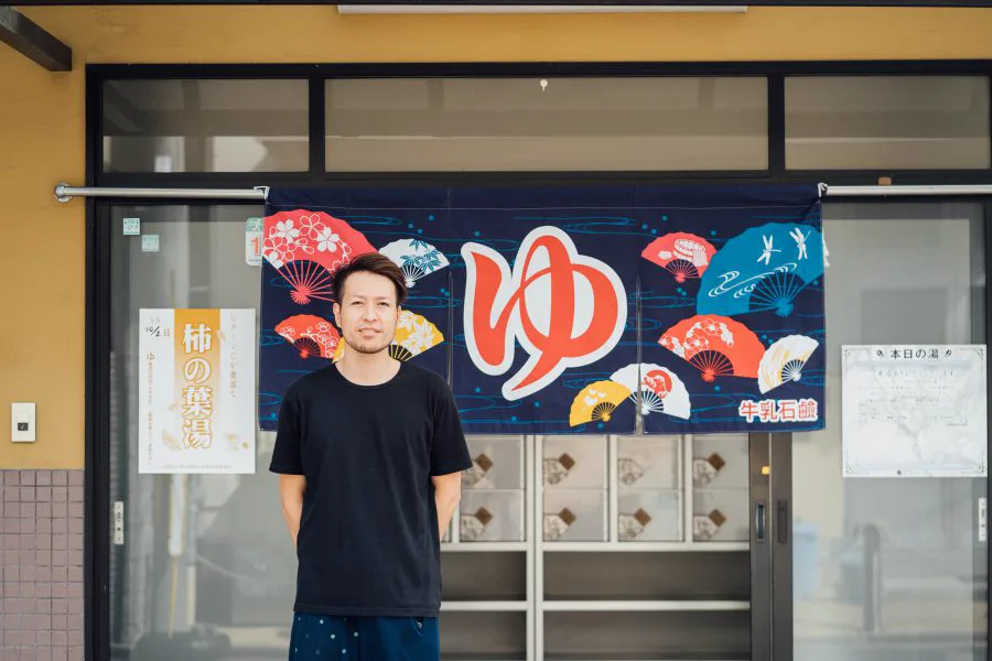 교토 동네 목욕탕 입구에 서 있는 직원